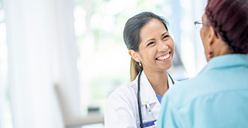 A doctor smiling while talking to a patient