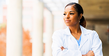 A confident, female doctor looking out a window